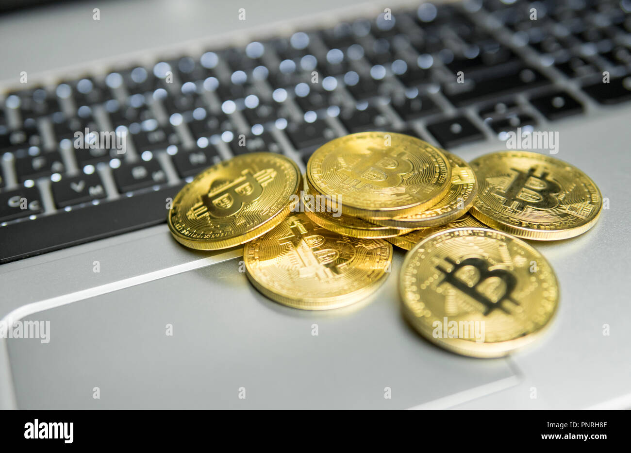 A Bunch Of Golden Bitcoin Coin On A Silver Keyboard Of Laptop - 